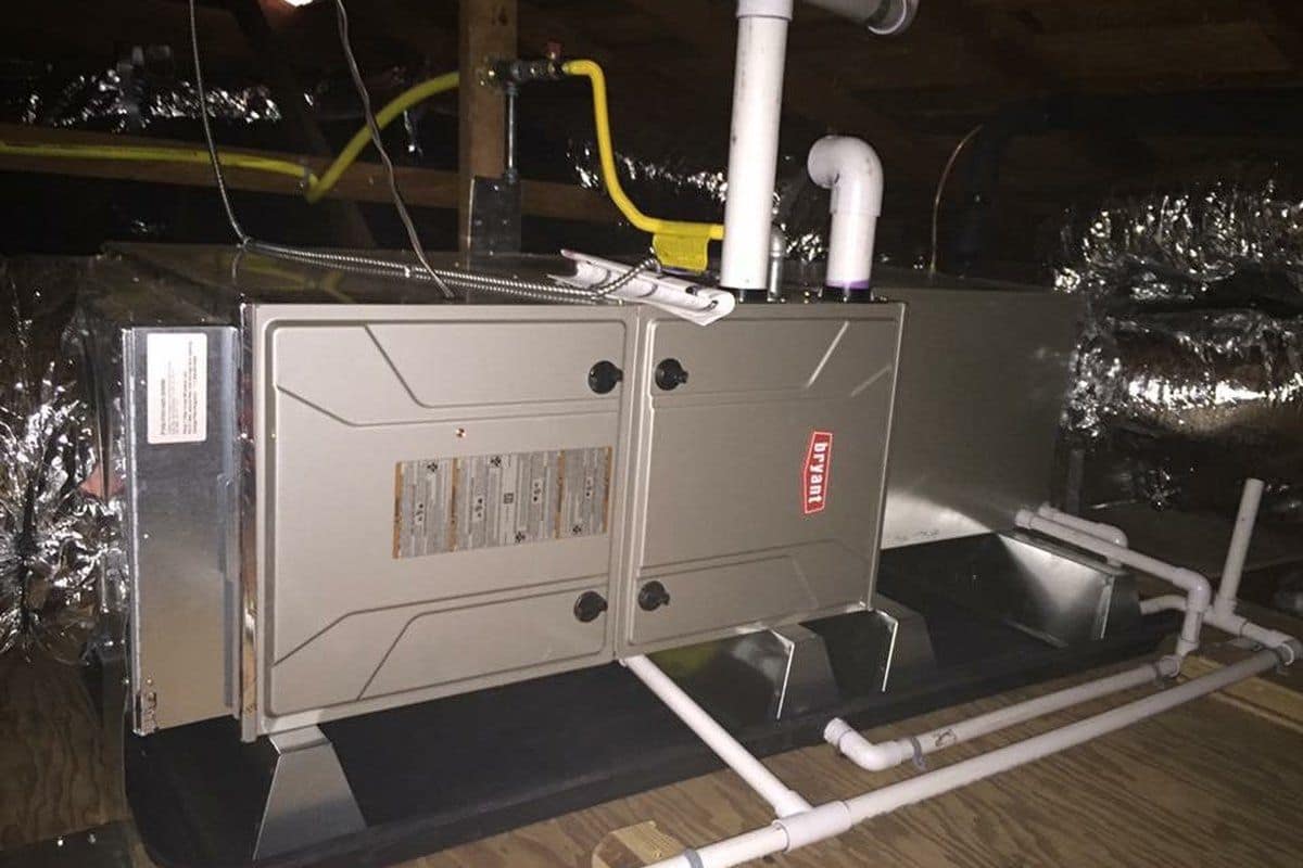 New high-efficiency Bryant gas furnace fully installed and connected in a residential attic